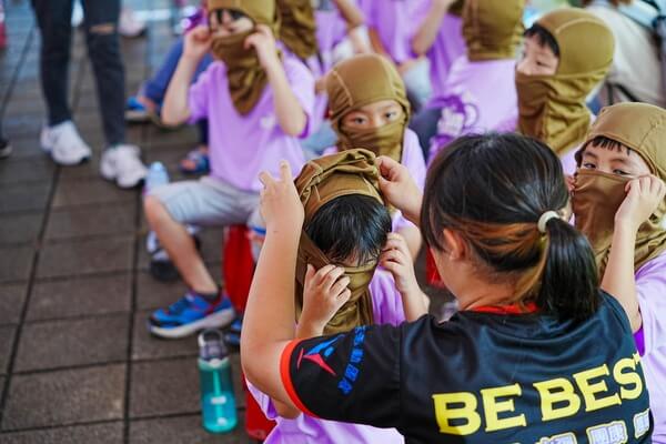 協助幼小孩童配戴飛虎帽：這些照片你只能在熊麻吉活動團隊看得到，因為別的水場地做不到